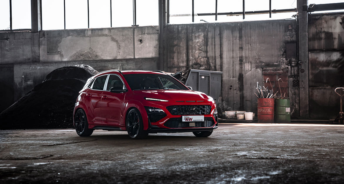 A red Hyundai Kona N with KW V3 coilovers in an industrial hall